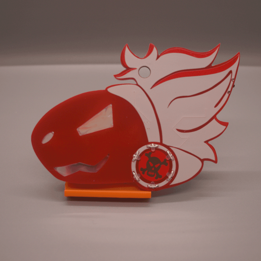 Photo of a red PCB badge in the shape of a protogen's head. They have a mad expression, and their facial features are cutouts in the PCB filled with hot glue. They have white hair, and a circle of LEDs on their cheek with a skull and crossbones made of copper in the middle.